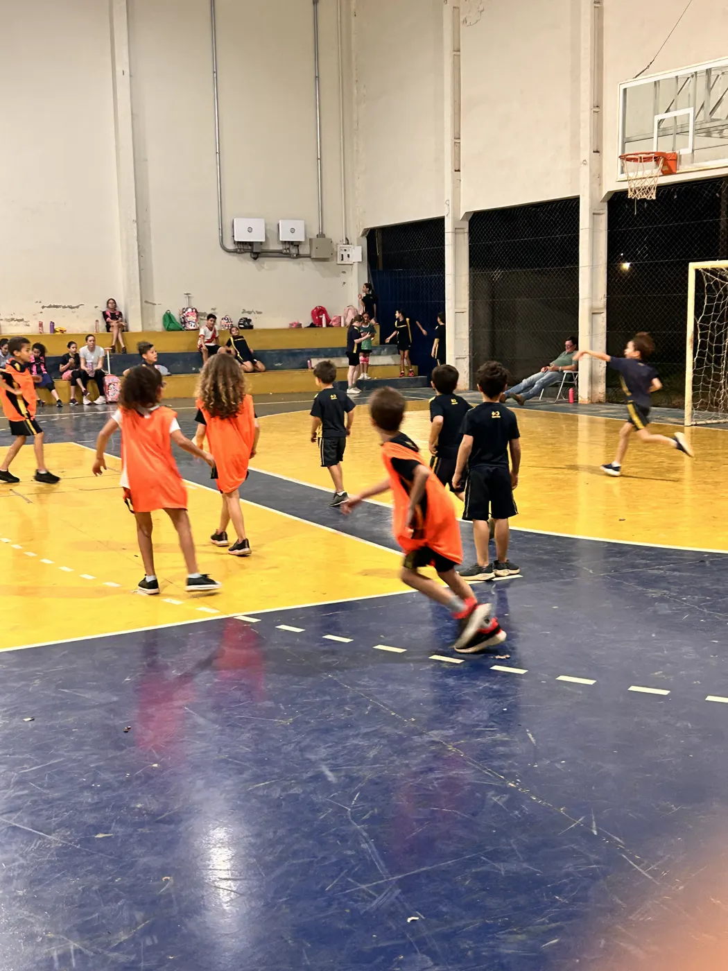 Alunos jogando futsal na quadra coberta